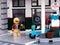 A Lego woman minifigure walking towards her moped that has just been filled up with fuel