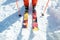 Legs athlete skier in an orange overall on a sport skiing on snow on a sunny day. The concept of winter sports