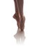 The legs of a ballerina in beige pointe