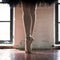 Legs of a ballerina closeup. The legs of a ballerina in old pointe. Rehearsal ballerina in the hall. Contour light from the window