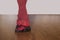 Legs of ballet dancer in fifth position with red foot warmers