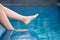 Legs and bare feet soaking water in the pool