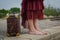 Legs with bare feet of woman with suitcase