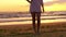 Legs barefoot ethnic girl in white dress on the beach at sunset.