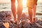 Legs on beach. Foot spa. A young loving couple hugging and kissing on the beach at sunset