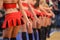 Legs of beautiful cheerleaders in red costume dancing in the are