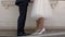 The legs of the bride and groom are standing opposite each other.