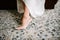 The legs of the bride in a wedding dress in shoes