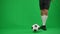 Legs of Caucasian sportsman catching passing football ball on green screen. Unrecognizable professional footballer