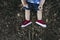 Legs of child sitting in the grass with cute sneakers shoes