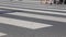 Legs of crowd people walking on the pedestrian crossing. Close-up of crowd feet.