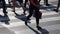 Legs of crowd people walking on the pedestrian crossing. Close-up of crowd feet. City crowd.