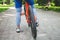 Legs of a cyclist and part of a bicycle on a dirt road