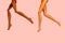 legs of dolls with different skin color on pink background, hair removal and skin care concept