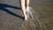 Legs Elderly Caucasian Man Walking Along The Shore In The Water With Black Sand