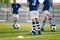 Legs of european football boys kicking balls on field