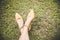 Legs with fashion high heel shoes yellow on green grass with copy space. Vintage tone