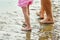 Legs of a father and son on the beach