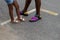 Legs and feet of African American father and daughter wearing summer colorful sandals and shorts