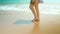 Legs feet caucasian girl walking barefoot wet sand island beach. Close Up Shot.