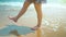 Legs feet caucasian girl walking barefoot wet sand island beach. Slow Motion. Close Up Shot.