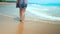Legs feet caucasian girl walking barefoot wet sand island beach. Slow Motion. Close Up Shot.