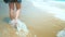 Legs feet caucasian girl walking barefoot wet sand island beach. Slow Motion. Close Up Shot.