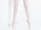 Legs and feet with pink satin pointe shoes by a classic ballerina on tiptoe