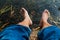 Legs and feet relaxing in front of serene fresh water pond