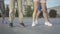 Legs of four unrecognizable men and women dancing modern dance outdoors. Group of joyful young Caucasian people