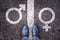 Legs with gender symbol on asphalt