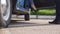 Legs of girl getting out of old auto. Man opens and holds door of retro car for young woman in high heels shoes