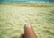 Legs of a girl lying on a beach deckchair by the sea. The sun, painted on sunburnt skin of the foot with sunscreen