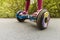 Legs of girl riding on self-balancing mini hoverboard in city Park. Electronic scooter outdoors - personal portable eco transport