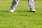 Legs of golfer on green field