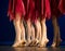 Legs of a group of ballerinas in red skirts