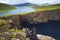 Legs of hiker sitting on top of a cliff over lake Sorvagsvatn on Faroe Islands