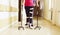 Legs of invalid in orthosis walking with support of two walking cane