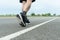 The legs of male athletes in black shoes are preparing to run on the paved road Outdoor exercise for weight loss and good health.