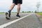 The legs of male athletes in black shoes are preparing to run on the paved road Outdoor exercise for weight loss and good health.