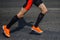 legs male runner in black compression socks and bright running shoes