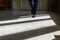 Legs of a man in an expensive suit and black shoes during a step. A person walks along the corridor of the living room or hotel ma