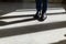 Legs of a man in an expensive suit and black shoes during a step. A person walks along the corridor of the living room or hotel ma