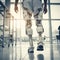 Legs of man in the robotic exoskeleton walking through the corridor of the rehabilitation clinic. Doctor helping him