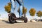 Legs of a man standing on e-scooter parked on sidewalk at cityscape on the sunset. Trendy urban transportation on modern