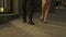 Legs of man and woman walking towards camera, couple going to club, night out