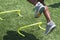 Legs with motion blur jumping over small hurdles on a turf field