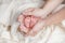 Legs of a newborn baby in the arms of his mother, on a white light background, motherly love and tenderness