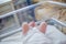 Legs of a newborn baby lying in a couveuse. The child has just been born and is in the hospital clinic with his mother. Natural