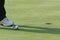 Legs of a person playing golf in the field